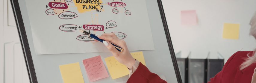 Femme organisant son business plan e-commerce sur un tableau plan